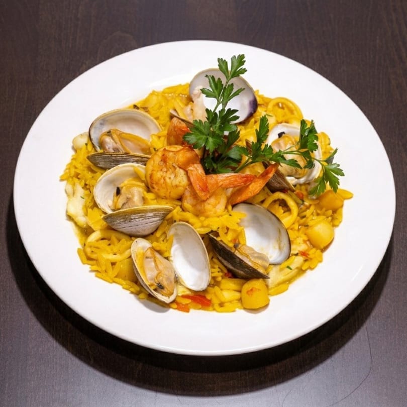 A vibrant seafood paella with shrimp, clams, and squid, garnished with fresh parsley on a white plate.